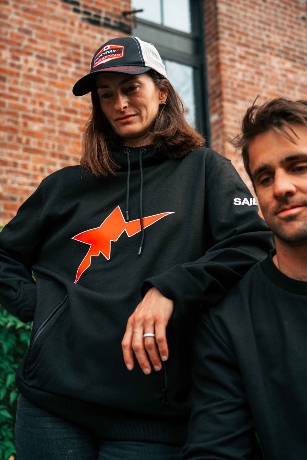 NorthStar SailGP fans wearing black branded hoodies and a trucker cap